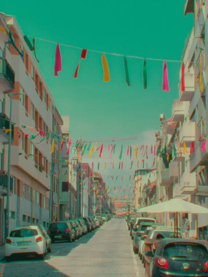 Strings of colourful bunting above a narrow city street