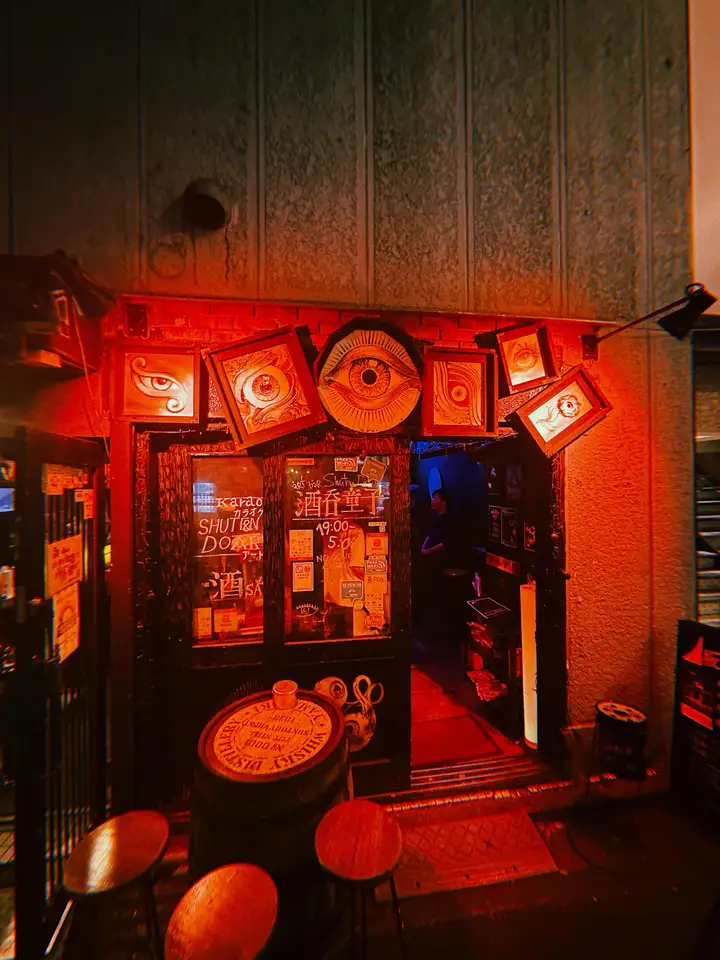 A red-lit storefront covered in glowing signs at night