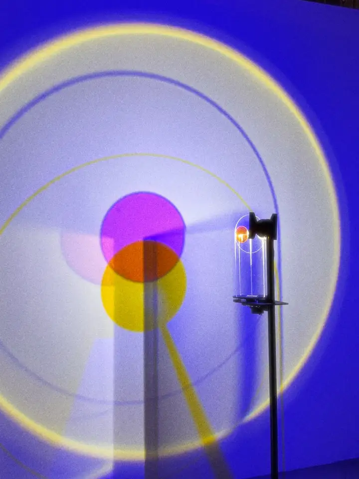 Overlapping coloured circles against a violet wall