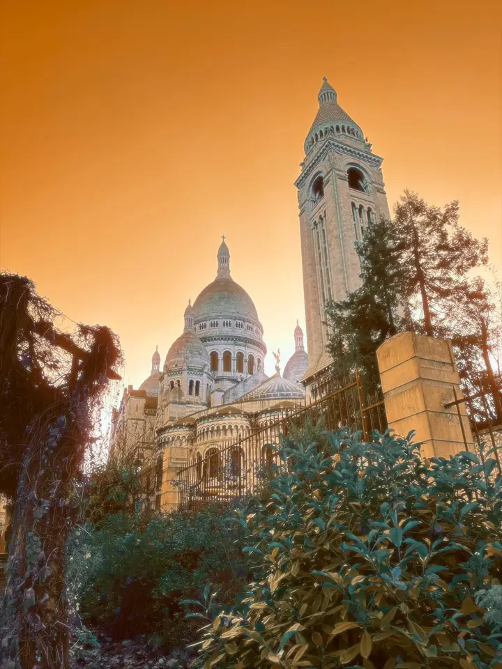 A white domed basilica beneath a golden sky